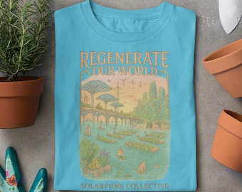 Może przedstawiać: Jasnoniebieska koszulka z nadrukiem graficznym przedstawiającym futurystyczne miasto z tekstem "REGENERATE OUR WORLD" i "SOLARPUNK COLLECTIVE".