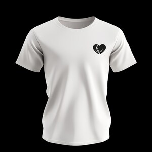 Op de afbeelding: Wit t-shirt met een zwart gebroken hart op de borst. Het shirt met korte mouwen is gemaakt van een zachte stof en heeft een ronde hals. Het ontwerp is eenvoudig en minimalistisch.