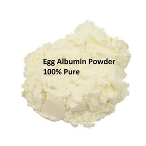 Può includere: Primo piano di un mucchio di polvere di albume d'uovo color avorio. Il testo "Egg Albumin Powder 100% Pure" è stampato sulla polvere.