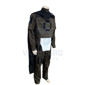 May include: A brown and black costume with a cape, jacket, and pants. The jacket has black patches and white stitching. The costume includes a black cape and a white panel on the front. The outfit is displayed on a mannequin.