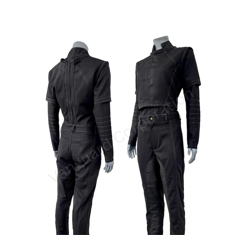 Puede incluir: Un mono negro de manga larga y cuello alto. El mono tiene una cremallera en la espalda y un ojal para el cintur&oacute;n. El pantal&oacute;n tiene una pierna recta.