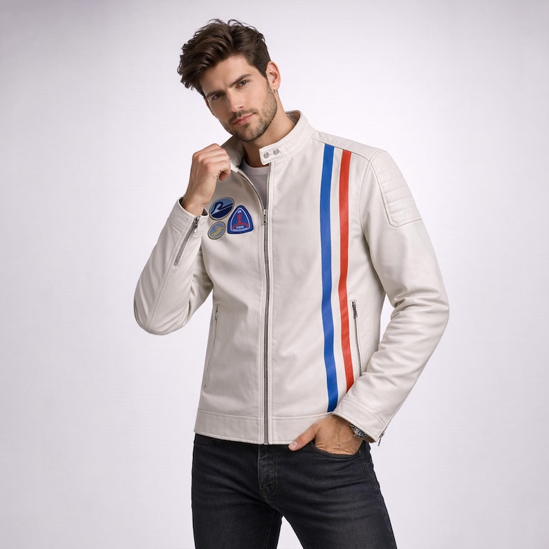 May include: Cream leather jacket featuring a vertical red and blue stripe. The jacket has a zip closure, patches on the chest, and a quilted shoulder design. The model is wearing black jeans.