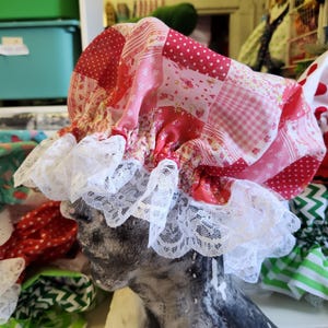 Op de afbeelding: Een verzameling kleurrijke douchecaps van stof met kantversiering. De caps zijn gemaakt van patchwork stof met verschillende patronen, waaronder stippen, ruitjes en bloemenprints.