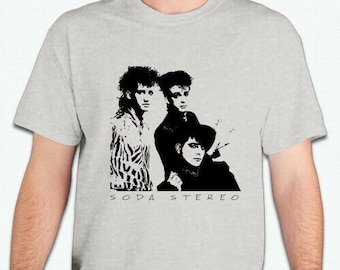 May include: A grey t-shirt with a black and white image of a band, Soda Stereo. The band members are wearing black clothing and have their hair styled in a similar fashion.