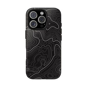 May include: Black phone case with a topographic map design. The case has a glossy finish and a detailed pattern of white contour lines against a black background. The phone case has a camera module with multiple lenses.