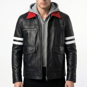 May include: A black leather jacket featuring a grey hooded sweatshirt layer underneath, a bright red collar, and two horizontal white stripes on each sleeve. The jacket includes a front zip closure, two flap pockets, and a zipped chest pocket.