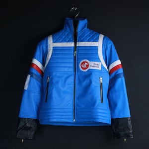 May include: A bright blue jacket with a high collar, featuring white horizontal stripes, red and blue sleeve accents, and black cuffs. A circular patch on the chest displays a red horse icon and the text Dead Pegasus. It has a front zipper.