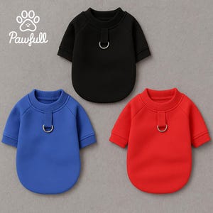 May include: Three dog sweaters in black, blue, and red. Each sweater has short sleeves, a crew neck, and a metal D-ring detail. The brand name "Pawfull" is printed in white script in the upper left corner.