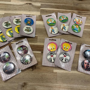 Puede incluir: Colección de botones vintage con personajes de dibujos animados como los Simpson, Piolín, Silvestre y las Tortugas Ninja. Los botones están en su embalaje original.