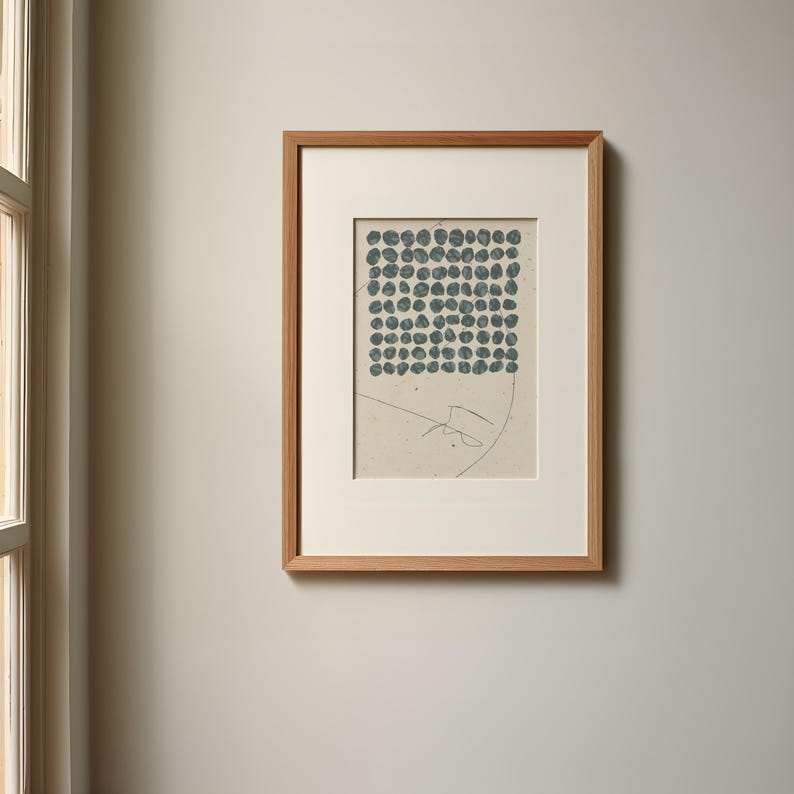 May include: A framed print with a light beige background and a square pattern of dark blue circles. The print has a light brown wooden frame.