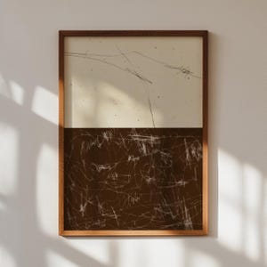 May include: A framed abstract art print with a brown background and white lines. The top half of the print is a light beige color with white lines.