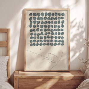 May include: A framed abstract print with a pattern of blue circles on a white background. A thin black line is drawn across the print.