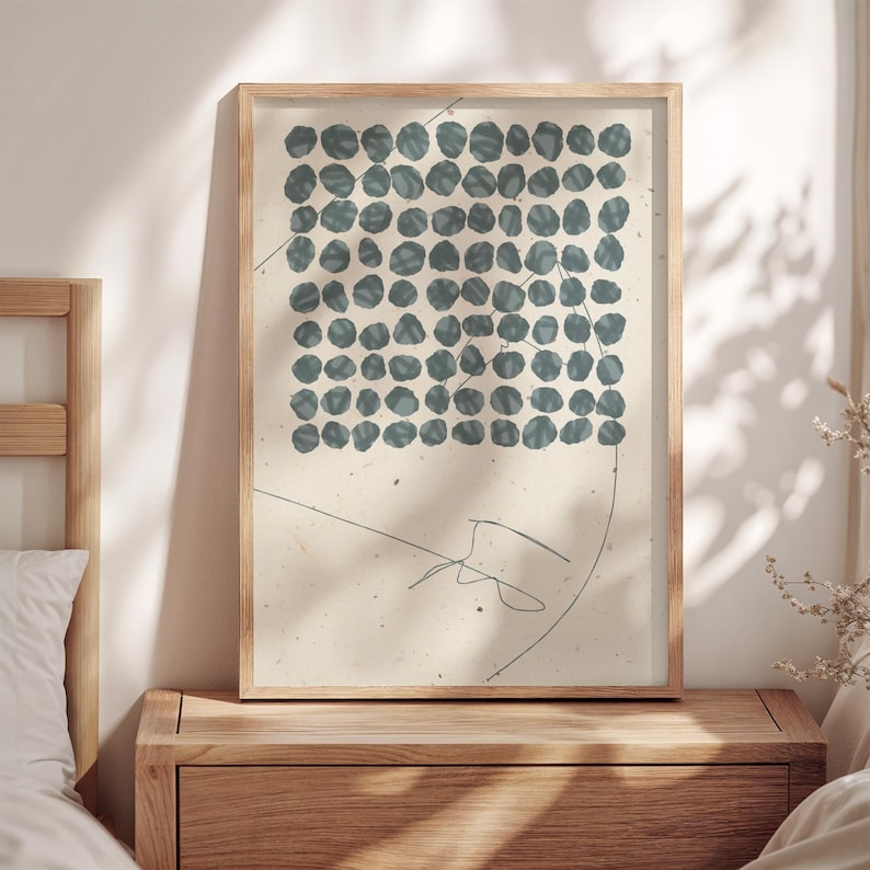 May include: A framed abstract print with a pattern of blue circles on a white background. A thin black line is drawn across the print.