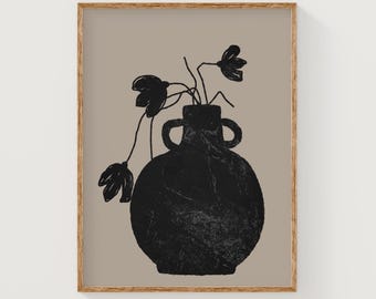 May include: A framed art print featuring a black vase with two handles, holding black floral stems against a tan background. The artwork has a minimalist, abstract style, with a wooden frame.