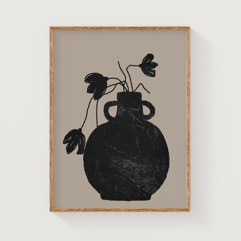 May include: A framed art print featuring a black vase with two handles, holding black floral stems against a tan background. The artwork has a minimalist, abstract style, with a wooden frame.
