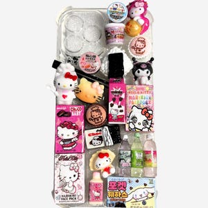 Könnte beinhalten: Eine transparente Handyhülle gefüllt mit verschiedenen Artikeln zum Thema Hello Kitty. Die Artikel umfassen Miniaturflaschen, Snacks, Figuren und Gesichtsmasken, alle in Rosa, Weiß und Schwarz. Einige Artikel haben japanischen Text.
