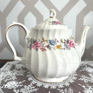 Teiera vintage Sadler in porcellana Bone China, bianca a coste, con ghirlanda floreale e bordo dorato.