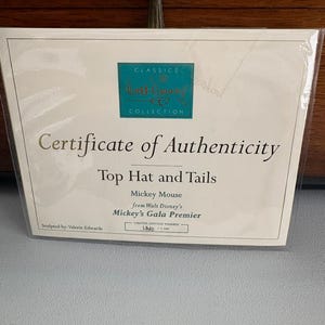 May include: A certificate of authenticity from the Classics Collection, featuring the text "Top Hat and Tails" and "Mickey Mouse from Walt Disney's Mickey's Gala Premier." The certificate is a limited edition, number 1540 of 7,500.