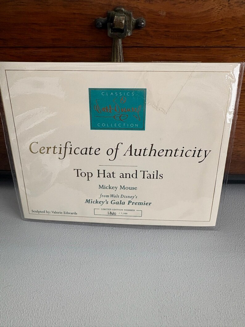 May include: A certificate of authenticity from the Classics Collection, featuring the text "Top Hat and Tails" and "Mickey Mouse from Walt Disney's Mickey's Gala Premier." The certificate is a limited edition, number 1540 of 7,500.