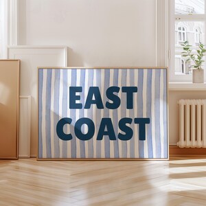 May include: A blue and white striped canvas print with the text "EAST COAST" in dark blue letters.
