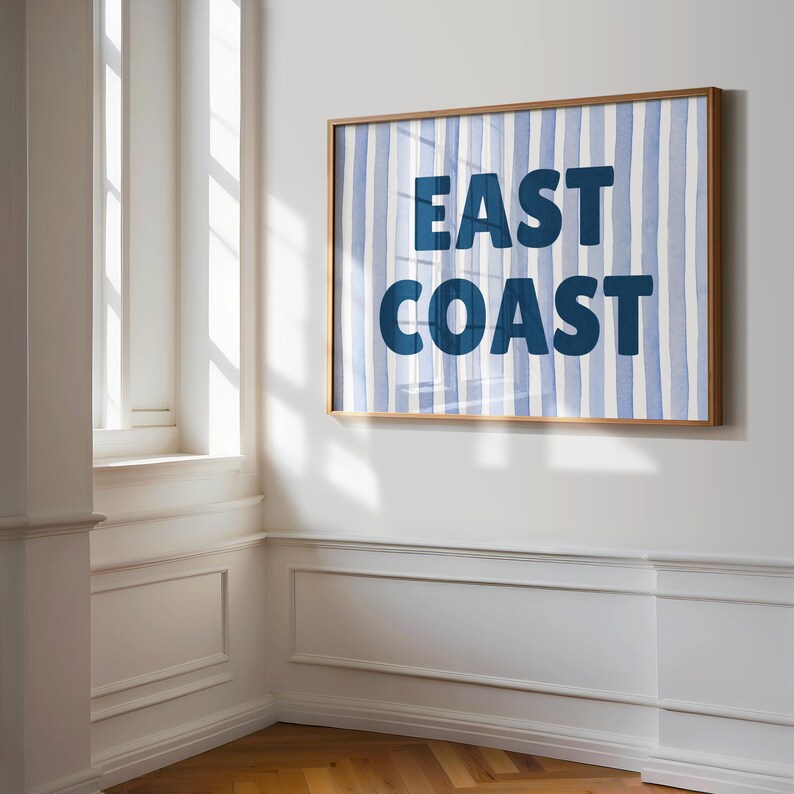 May include: A framed print with a blue and white striped background and the text "EAST COAST" in bold blue letters.