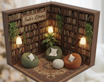 May include: A miniature diorama ornament depicting a cozy library scene. The ornament features a brown bookshelf, three beanbag chairs, a patterned rug, and the text "Jade's Library". The scene is illuminated by small lamps and a plant.