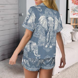 Peut inclure: Ensemble de pyjama bleu avec un motif d'&eacute;l&eacute;phant. Le haut &agrave; manches courtes et le short pr&eacute;sentent une illustration d&eacute;taill&eacute;e d'&eacute;l&eacute;phant blanc et des motifs d&eacute;coratifs. L'ensemble a une bordure blanche et est fait d'une mati&egrave;re douce et confortable.