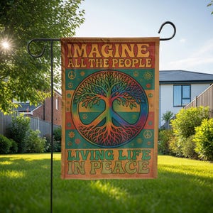 May include: A rectangular garden flag with the text "IMAGINE ALL THE PEOPLE" at the top and "LIVING LIFE IN PEACE" at the bottom. The flag features a colourful tree design with a peace sign in the centre, surrounded by peace symbols and flowers.