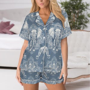 Peut inclure: Ensemble de pyjama bleu avec un motif d'&eacute;l&eacute;phant. L'ensemble comprend une chemise boutonn&eacute;e &agrave; manches courtes et un short assorti, tous deux bord&eacute;s d'un passepoil blanc. Le motif d'&eacute;l&eacute;phant est blanc.