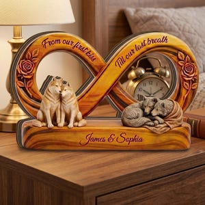 May include: A wooden infinity-shaped decorative piece featuring two carved roses, two pairs of wolves, and a gold-toned alarm clock. The text reads "From our first kiss" and "Till our last breath" with the names "James & Sophia" printed on the base.