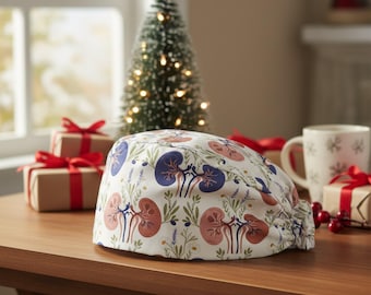 May include: A white scrub cap featuring a repeating pattern of anatomical kidney illustrations in shades of pink and blue, interspersed with green botanical sprigs, lavender stalks, and small white flowers, finished with an elasticized back.