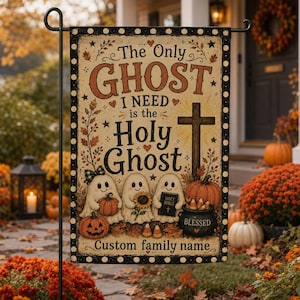May include: A rectangular garden flag with a cream background and black polka dot border. It features three white ghost illustrations, a brown cross, pumpkins, a sunflower, and a black pot. Text reads: The Only GHOST I NEED is the HOLY GHOST.