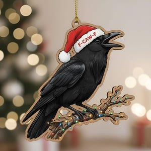 以下が含まれることがあります： 「F-CAW-F」の文字が入ったサンタ帽をかぶった黒いカラスの木製クリスマスオーナメント。カラスはカラフルなライトで飾られた枝にとまっています。オーナメントは木製で、吊り下げ用の金色の紐が付いています。