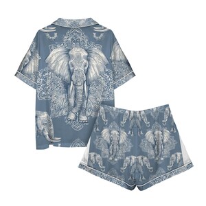 Peut inclure: Un ensemble de pyjama deux pi&egrave;ces bleu clair avec un motif d'&eacute;l&eacute;phant. Le haut &agrave; manches courtes et le short pr&eacute;sentent un motif r&eacute;p&eacute;t&eacute; d'&eacute;l&eacute;phants et de d&eacute;tails orn&eacute;s. L'ensemble est bord&eacute; d'un passepoil blanc.