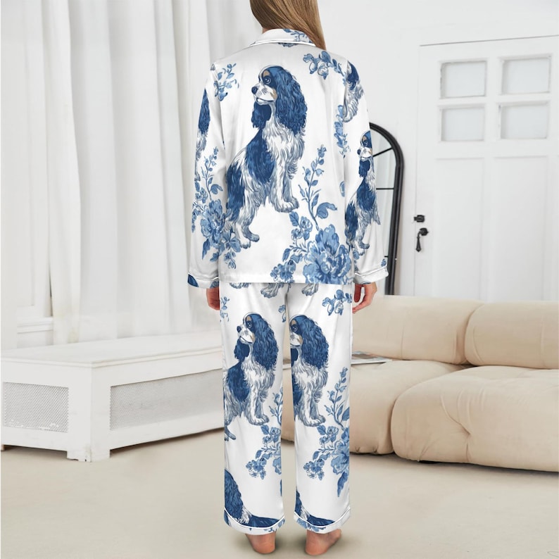 Puede incluir: Conjunto de pijama blanco con un estampado floral y de Cavalier King Charles Spaniel azul y blanco. La parte superior de manga larga y los pantalones presentan un estilo de camisa con botones y un ajuste relajado. El pijama est&aacute; hecho de un material suave y sedoso.