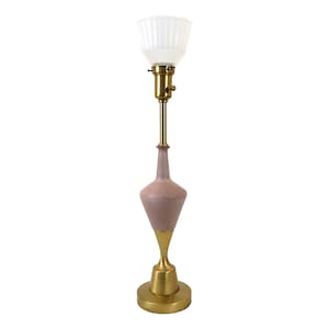 May include: A vintage table lamp with a pink, hourglass-shaped ceramic base and a brass stem and base. The lamp has a white, ribbed glass shade and a brass socket. The lamp is approximately 24 inches tall.
