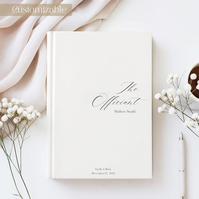 Puede incluir: Libro color crema con las palabras "The Officiant" en escritura elegante. Debajo del t&iacute;tulo est&aacute; el nombre "Mathew Smith". En la parte inferior del libro est&aacute;n los nombres "Emily & Jon" y la fecha "17 de diciembre de 2026".