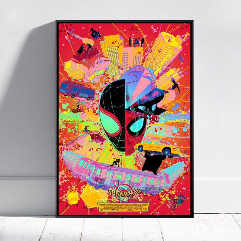 May include: A framed poster featuring a split Spider-Man mask design against a vibrant red background. The artwork includes cityscapes, vehicles, and figures in action, with the words "Spider-Man" at the bottom.