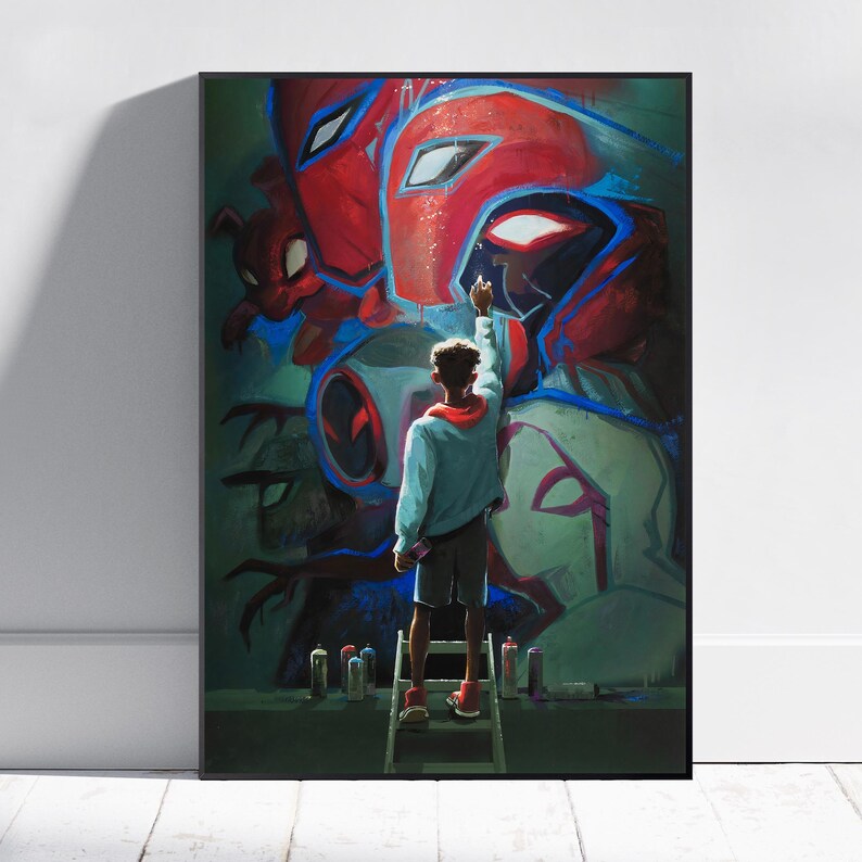 May include: A framed art print featuring a graffiti-style mural of superhero characters. A person on a ladder is depicted painting the mural with spray paint cans at their feet. The artwork is dominated by red, blue, and green hues.