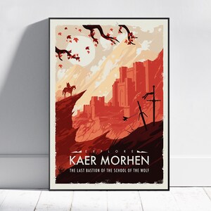 May include: A framed poster featuring a stylized illustration of a castle and a rider on horseback. The artwork is in shades of red and orange, with the text "EXPLORE KAER MORHEN" and "THE LAST BASTION OF THE SCHOOL OF THE WOLF".