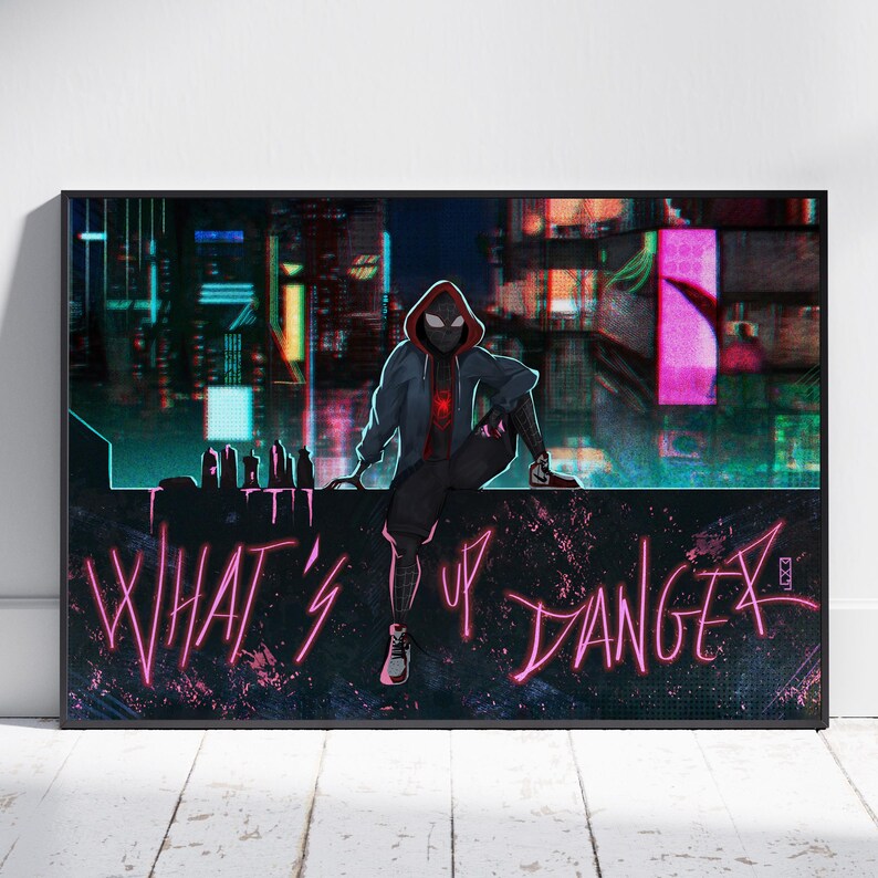 May include: A framed art print featuring a character in a black and red suit, sitting on a ledge with the words "WHAT'S UP DANGER" in pink neon. The background shows a cityscape with colorful lights.