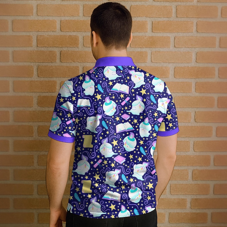 May include: A short-sleeved polo shirt with a dark blue background and a repeating pattern of white figures, books, stars, and feathers. The shirt has purple trim on the collar and sleeves.