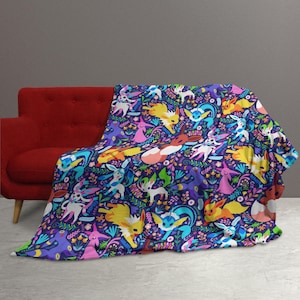 May include: A soft throw blanket featuring a repeating pattern of various colorful Eevee evolution characters set against a dark purple background filled with small flowers, leaves, and botanical elements in shades of blue, pink, and yellow.