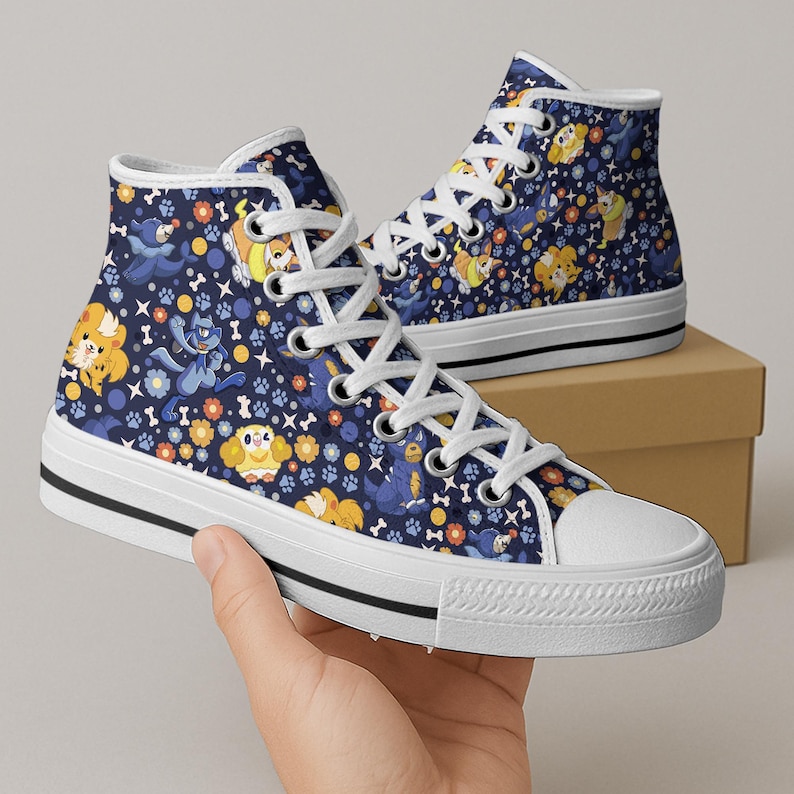 May include: High-top canvas sneakers with a navy blue background and a repeating pattern of cartoon dogs, flowers, and paw prints. The shoes have white laces, a white toe cap, and a black stripe on the white sole.