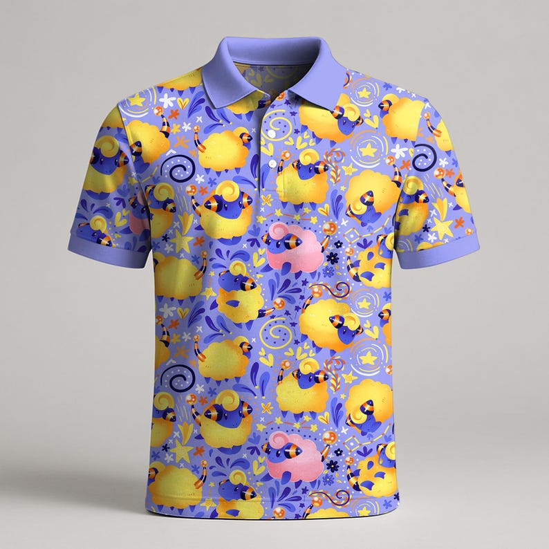 May include: A short-sleeved polo shirt with a whimsical pattern of yellow and pink sheep on a lavender background. The shirt has a light purple collar and sleeve cuffs. The sheep are decorated with blue accents and surrounded by stars and floral elements.