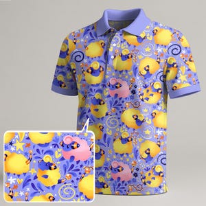 May include: A short-sleeved polo shirt with a whimsical sheep pattern. The shirt features a light purple collar and sleeves, and a repeating pattern of yellow and pink sheep on a blue background. The sheep are decorated with blue and black accents.