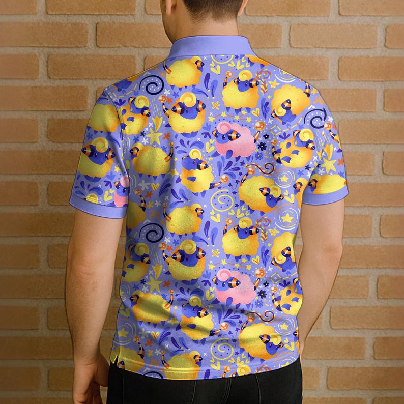 May include: A short-sleeved polo shirt with a repeating pattern of cartoon sheep in yellow, blue, and pink on a lavender background. The shirt has a light blue collar and sleeve cuffs. The person is standing in front of a brick wall.