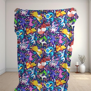 May include: A rectangular throw blanket featuring a repeating pattern of various colorful Eevee evolution characters set against a dark purple background filled with vibrant floral and leaf motifs in shades of pink, blue, and green.