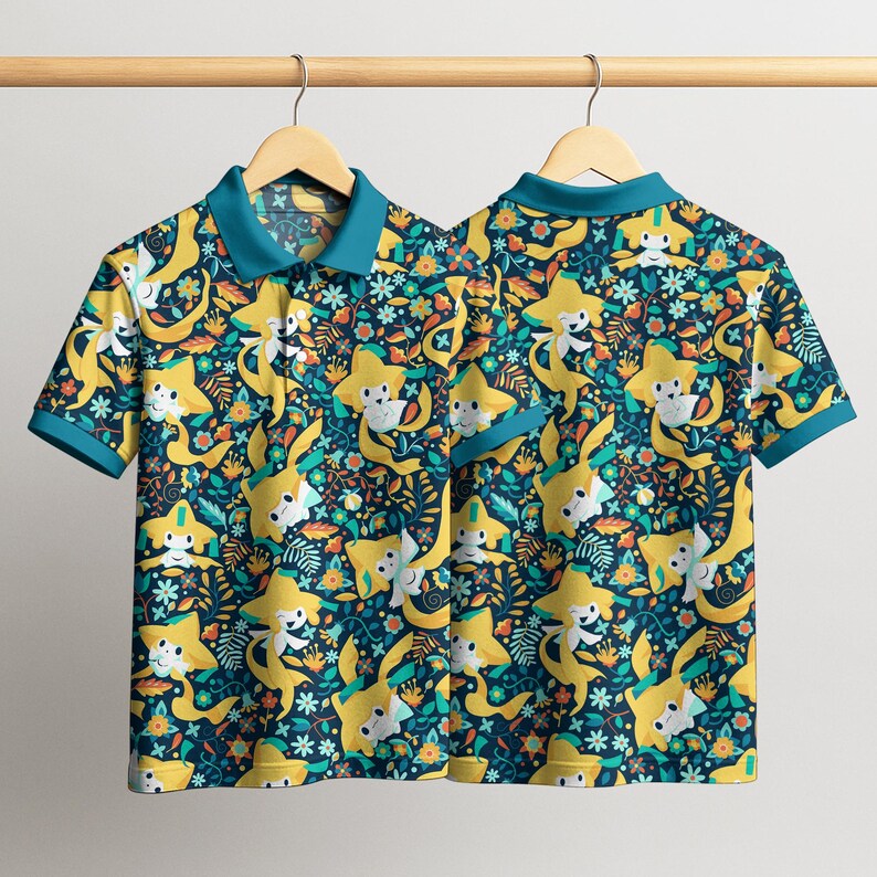 May include: Two short-sleeved polo shirts hanging on a wooden rack. The shirts feature a repeating pattern of yellow star-shaped characters with white faces, set against a dark teal background with floral and leaf accents. The collars and sleeve cuffs are teal.