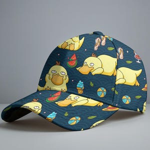 Puede incluir: Gorra de béisbol azul marino con un estampado repetido de patos amarillos de dibujos animados, rodajas de sandía, conos de helado, pelotas de playa y chanclas. La gorra tiene una visera curva y un botón en la parte superior.